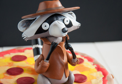 "Secret Pizza Party"s raccon sits on top of this pizza cake