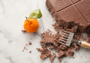 Chopping large block of milk chocolate with chocolate chopper